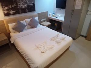 a bedroom with a white bed with two flowers on it at Pratunam19 Hotel in Bangkok