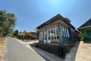 una pequeña casa sentada al costado de una carretera en OYO Life 92982 Kost Berkah Ibu, en Lawang