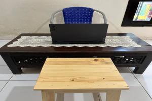 um portátil sentado em cima de uma mesa com um banco em OYO Life 92982 Kost Berkah Ibu em Bukit Lawang