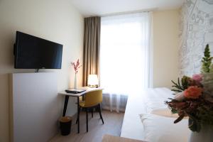 TV a/nebo společenská místnost v ubytování Kreuz Bern Modern City Hotel