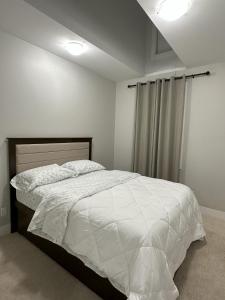 a bedroom with a bed with a white comforter at Dhimanz Residence in Surrey