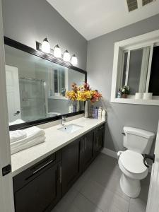 La salle de bains est pourvue de toilettes, d'un lavabo et d'un miroir. dans l'établissement Dhimanz Residence, à Surrey