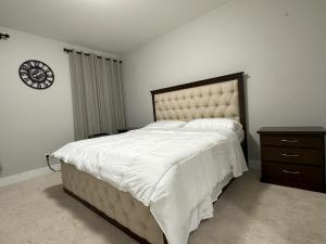a bedroom with a large bed and a clock on the wall at Dhimanz Residence in Surrey