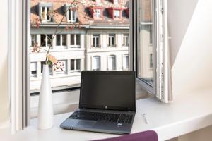 a laptop sitting on a desk in front of a window at Kreuz Bern Modern City Hotel in Bern