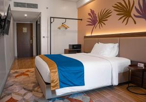 a bedroom with a large bed and a television at Kingsford Hotel Manila Bay in Manila