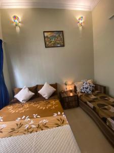 - une chambre avec deux lits et deux lumières sur le mur dans l'établissement Mystic Dreamville 3BHK Villa Lonavala, à Lonavala