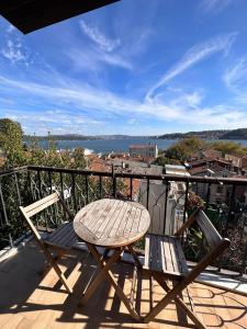 a wooden table and two chairs on a balcony at Historic Wooden House with Bosphorus view in Sarıyer