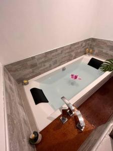 a white bath tub with a pink flower in it at Fare Miti-Rapa in Tohautu
