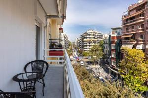 a balcony with two chairs and a view of a city at The five star apartment-Tsimiski street in Thessaloniki