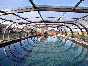 una piscina con un gran techo de cristal en Le Bout du pré, 