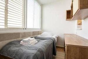 a bedroom with a bed with towels on it at "One minute from sea" from Shneider Apartments in Haifa