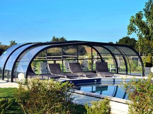 basen z leżakami pod szklanym dachem w obiekcie Le Poulailler 