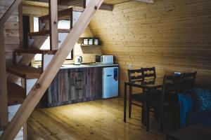 a kitchen and dining room in a log cabin at Luno Cottage in Stepantsminda