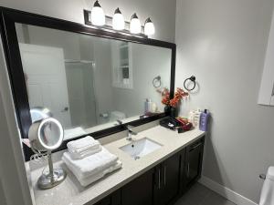 a bathroom with a sink and a large mirror at Dhimanz Residence in Surrey