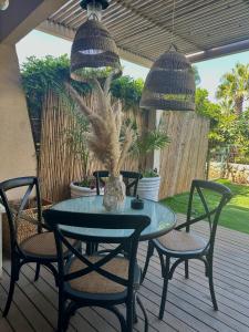 un tavolo e sedie su una terrazza con tavolo di Habostan ceasarea, הבוסתן בקיסריה a Caesarea