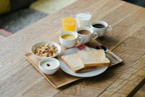 a plate of food with toast and cups of coffee at WeBase Hakata Hostel in Fukuoka