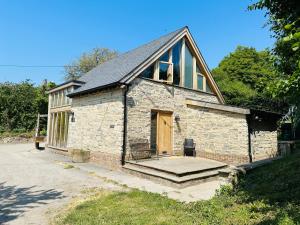 ein kleines Steingebäude mit einer Tür und einer Veranda in der Unterkunft Poet's Cottage, Steep - Rural Location - Sleeps 6 in Steep