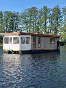 a house on a barge on the water at Hausboot NautikHus auf der Havel in Kolonie Zern