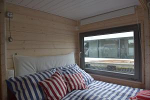 a bed in a small room with a window at Hausboot NautikHus auf der Havel in Kolonie Zern