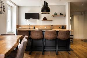 a kitchen with a bar with bar stools at L'appart' du dessous in Gérardmer