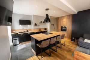 a kitchen with a island in the middle of a room at L'appart' du dessous in Gérardmer
