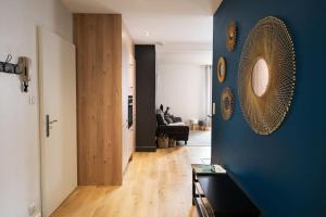 a living room with a blue wall with a mirror at L'appart' du dessous in Gérardmer