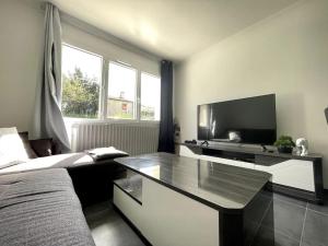 Maison Bleue ※ Carcassonne في قرقشونة: غرفة نوم بسرير وتلفزيون وطاولة