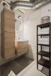 a bathroom with a sink and a shelf with towels at Le Bon'Apart Suites in Gorinchem