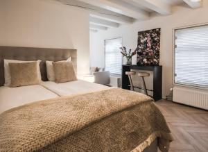a bedroom with a large bed and two windows at Le Bon'Apart Suites in Gorinchem