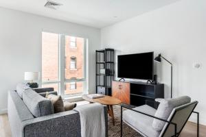 uma sala de estar com 2 sofás e uma televisão de ecrã plano em Central Sq 3BR w WD nr MIT Kendall Sq BOS-367 em Cambridge