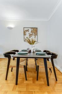 a dining room with a black table and chairs at Lux 2Bed 2Bath Apartment in Baker Street in London