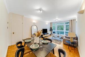 a dining room and living room with a table and chairs at Lux 2Bed 2Bath Apartment in Baker Street in London