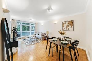 ein Wohnzimmer mit einem Tisch und Stühlen in der Unterkunft Lux 2Bed 2Bath Apartment in Baker Street in London