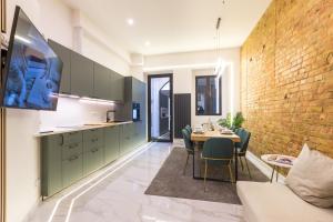 a kitchen and dining room with a table and a brick wall at Hevals Spa & Design Apartment in Berlin