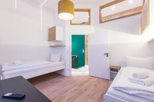 a living room with two beds and a table at Hevals Spa & Design Apartment in Berlin