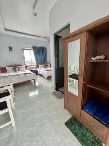 Habitación con sala de estar con sofá y habitación con: en Tony's House Hotel Mũi Né, en Ấp Thiện Phước