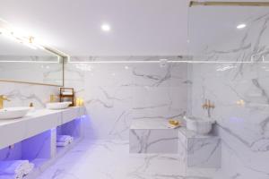 a white bathroom with two sinks and a shower at Hevals Spa & Design Apartment in Berlin