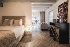 a bedroom with a bed and a living room at Le Bon'Apart Suites in Gorinchem