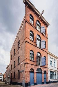 a brick building with a tower on the side of it at Le Bon'Apart Suites in Gorinchem