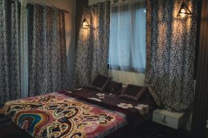 a bed in a room with curtains and a bed sidx sidx sidx sidx at Tulip Villa in Mulshi