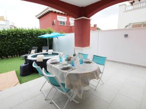 a table with chairs and an umbrella on a patio at Villa Amyali by Rentalole Mar Menor Golf Resort in Torre-Pacheco
