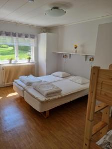 a bedroom with a large bed and two windows at Nyckelbo Vandrarhem in Helsingborg