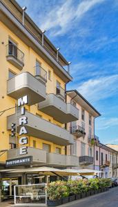 um grande edifício amarelo com uma placa para um hotel em Hotel Mirage em Viareggio