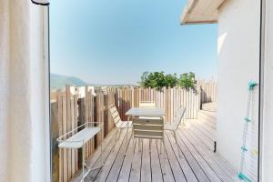 a balcony with a table and chairs on a wooden deck at Des Bulles en rooftop in Annecy
