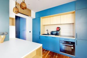 a kitchen with blue cabinets and a counter at Des Bulles en rooftop in Annecy