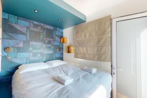 a bedroom with a white bed with a blue ceiling at Des Bulles en rooftop in Annecy