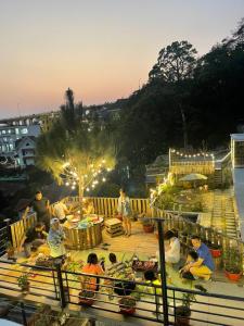 un grupo de personas sentadas en mesas en una terraza por la noche en Nắng Homestay, en Tam Ðảo