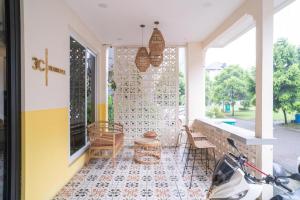当格浪Behomy 3C Residence near ICE BSD的一个带桌椅的门廊和一座建筑