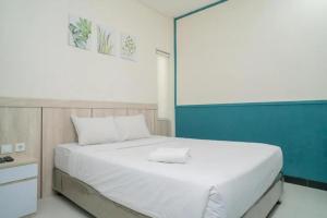 当格浪Behomy 3C Residence near ICE BSD的卧室里有一张白色的大床，墙壁是蓝色的 更多21张照片