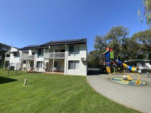 a apartment building with a playground in the yard at Mandalay Holiday Resort and Tourist Park in Busselton
